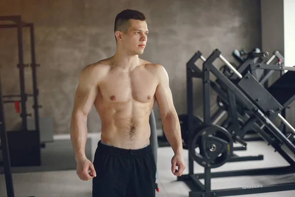 Un hombre guapo se dedica a un gimnasio — Foto de Stock