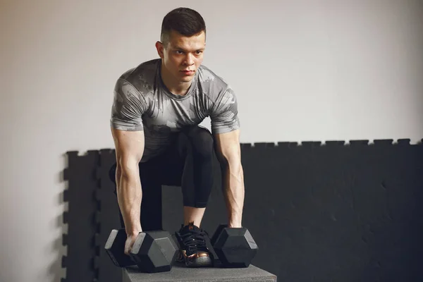 Un bell'uomo è impegnato in una palestra — Foto Stock