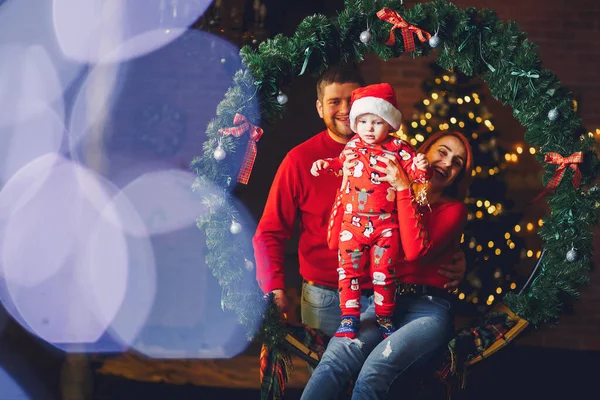 Family sitting at home near christmas tree — Stock Photo, Image