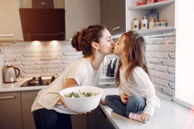 Evde güzel bir kızı olan bir anne.