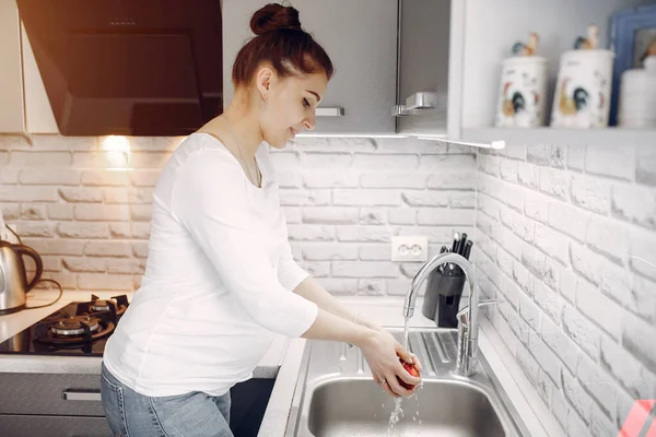 Chica elegante en una cocina con frutas — Foto de Stock