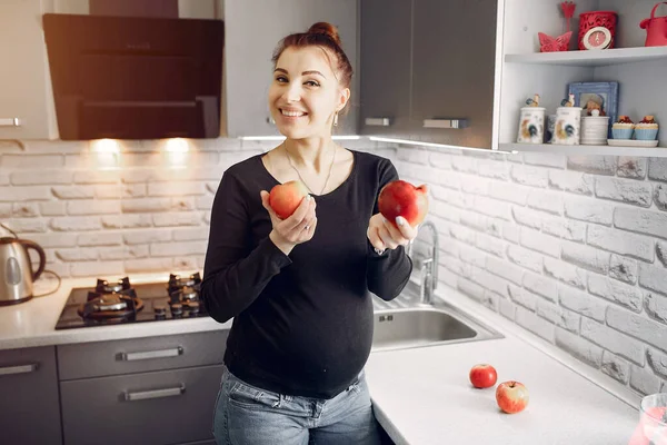 Chica elegante en una cocina con frutas — Foto de Stock