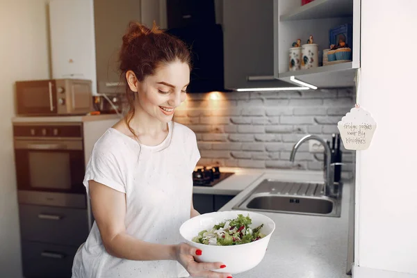 Chica elegante en una cocina con ensalada — Foto de Stock