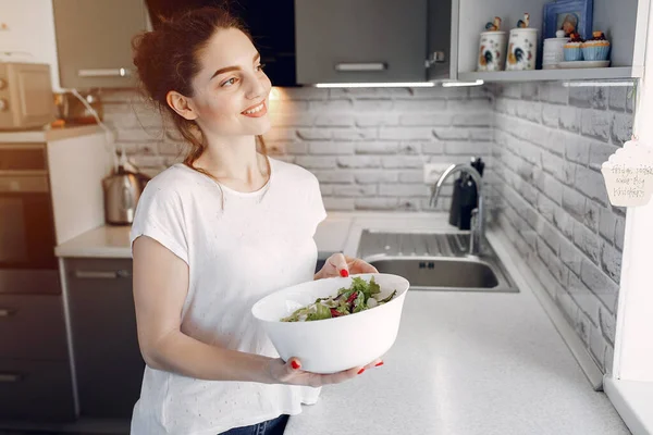 Chica elegante en una cocina con ensalada — Foto de Stock