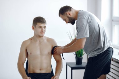 Doktor, hastanedeki bir atlete çadır yapıştırıyor.