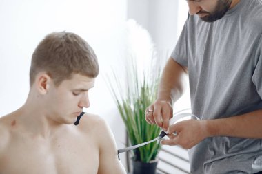 Doktor, hastanedeki bir atlete çadır yapıştırıyor.