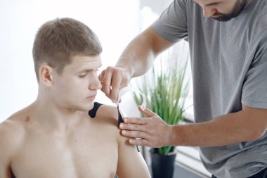 Doktor, hastanedeki bir atlete çadır yapıştırıyor.