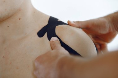 Doktor, hastanedeki bir atlete çadır yapıştırıyor.