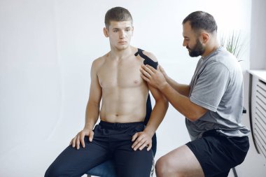 Doktor, hastanedeki bir atlete çadır yapıştırıyor.