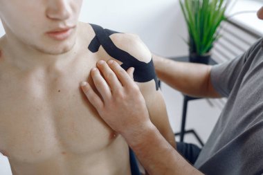 Doktor, hastanedeki bir atlete çadır yapıştırıyor.