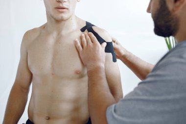 Doktor, hastanedeki bir atlete çadır yapıştırıyor.