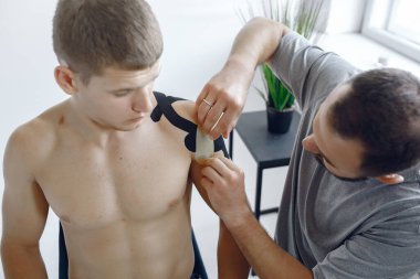 Doktor, hastanedeki bir atlete çadır yapıştırıyor.