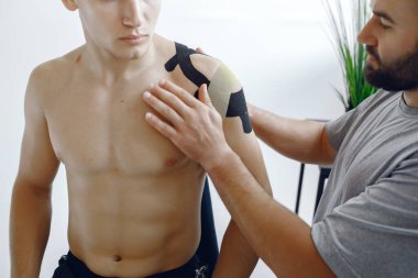 Doktor, hastanedeki bir atlete çadır yapıştırıyor.