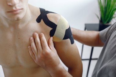 Doktor, hastanedeki bir atlete çadır yapıştırıyor.