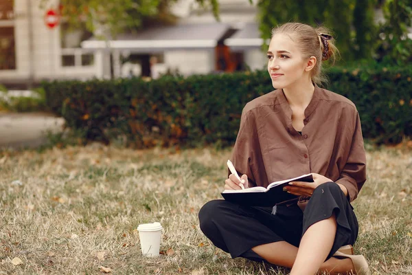 Nette Studentin arbeitet im Park und benutzt das Notizbuch — Stockfoto