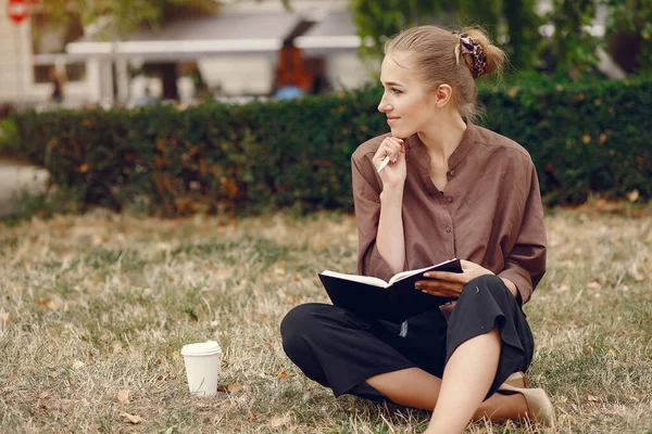 Nette Studentin arbeitet im Park und benutzt das Notizbuch — Stockfoto