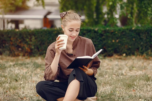 Estudante bonito que trabalha em um parque e usa o caderno — Fotografia de Stock