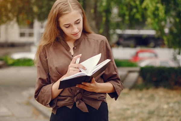 Estudante bonito que trabalha em um parque e usa o caderno — Fotografia de Stock