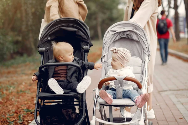 Две молодые матери, гуляющие в осеннем парке с экипажами — стоковое фото