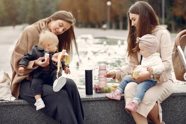 Två mammor med små barn vistas i en park — Stockfoto