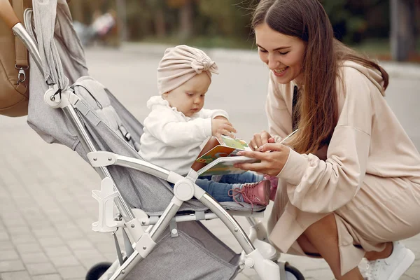 Ung mamma går i en höstpark med vagn — Stockfoto