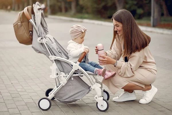 Ung mamma går i en höstpark med vagn — Stockfoto