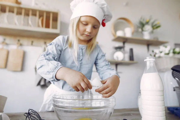 Little girl in a white shef hat cook the dough for cookies — Stockfoto