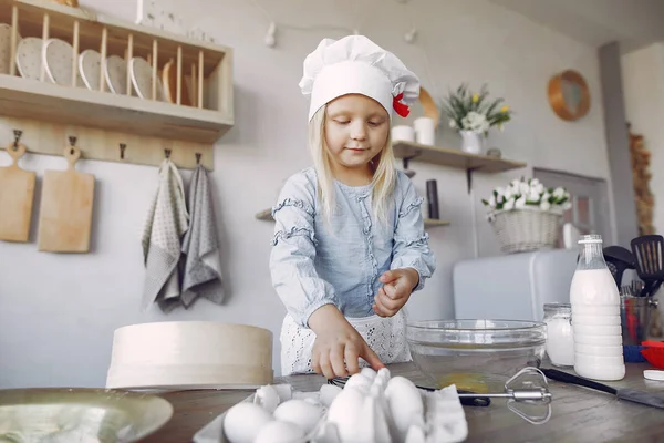 Bambina in un cappello bianco shef cuocere la pasta per i biscotti — Foto Stock