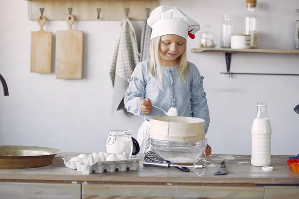 Little girl in a white shef hat cook the dough for cookies — Stock Photo, Image