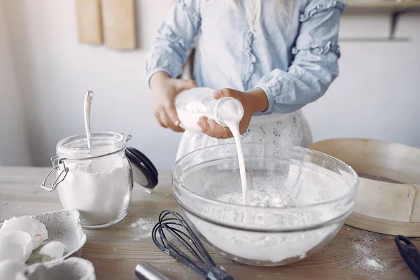 Little girl in a white shef hat cook the dough for cookies — Stockfoto