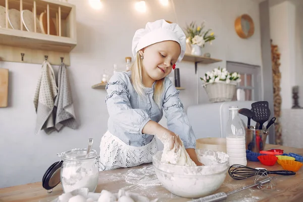 Little girl in a white shef hat cook the dough for cookies — Stockfoto