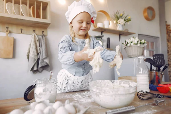 Bambina in un cappello bianco shef cuocere la pasta per i biscotti — Foto Stock