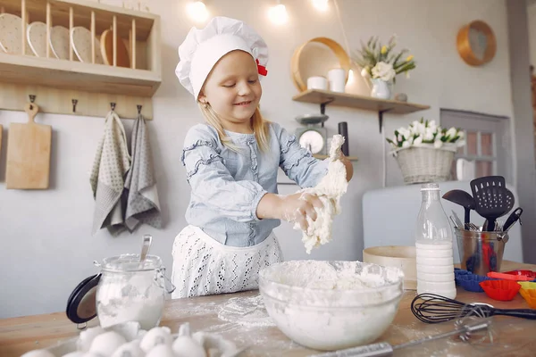 Bambina in un cappello bianco shef cuocere la pasta per i biscotti — Foto Stock