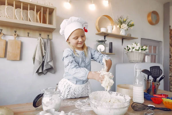 Little girl in a white shef hat cook the dough for cookies — Stockfoto