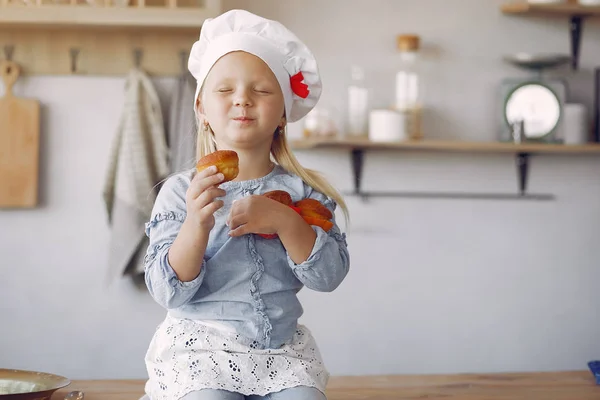 Linda niña en una cocina con magdalena — Foto de Stock