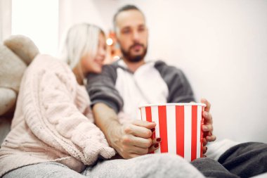 Couple sitting on a bed in a room with a popcorn
