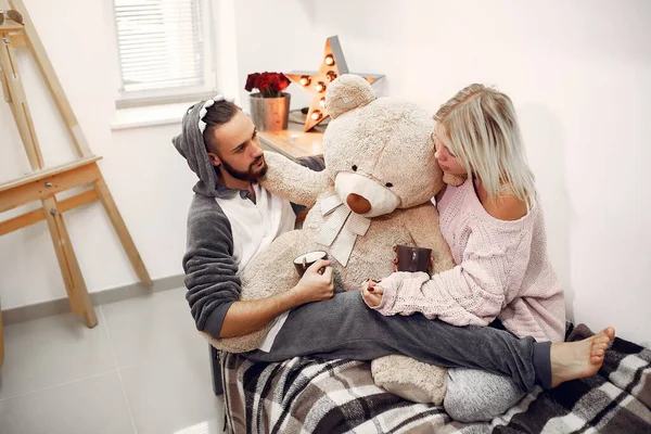 Couple sitting on a bed in a room drinking a coffee — Stockfoto