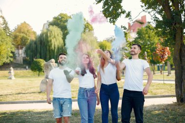 People have fun in a park with holi paints