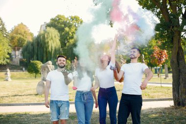 People have fun in a park with holi paints
