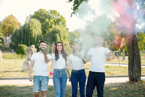 People have fun in a park with holi paints