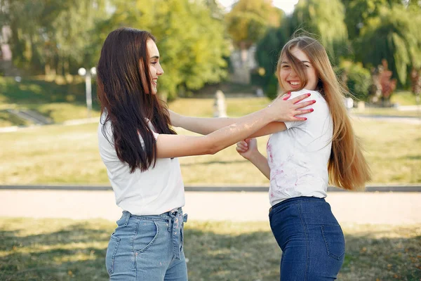 Dos chicas se divierten en un parque con pinturas holi — Foto de Stock