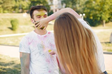 People have fun in a park with holi paints
