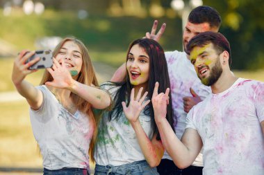 People have fun in a park with holi paints
