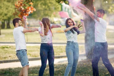 People have fun in a park with holi paints