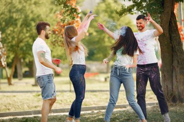 People have fun in a park with holi paints