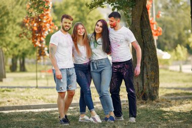People have fun in a park with holi paints