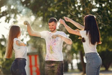 People have fun in a park with holi paints