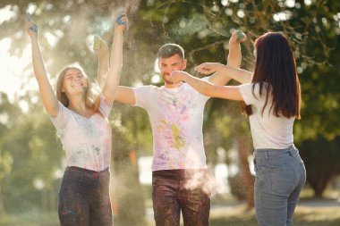 People have fun in a park with holi paints