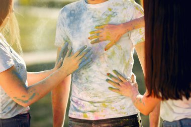 People have fun in a park with holi paints