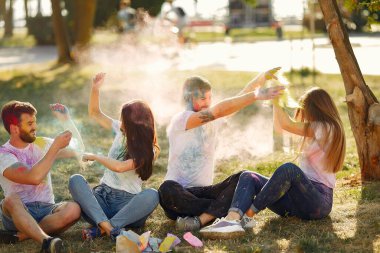 People have fun in a park with holi paints
